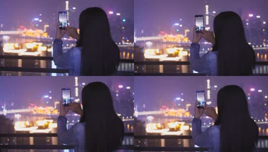 年轻女子在城市的夜晚拍照高清在线视频素材下载