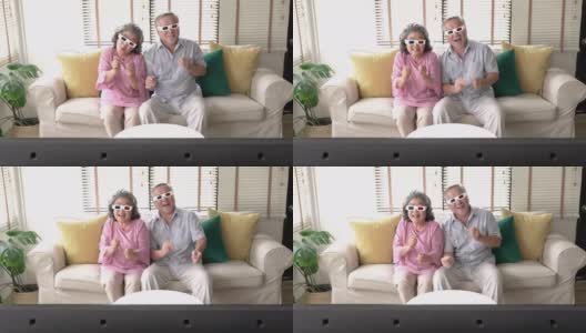 老两口在家里一起看电影激动的情绪。戴3d眼镜的老年男女。技术、娱乐和3d电影的概念。4 k决议。高清在线视频素材下载