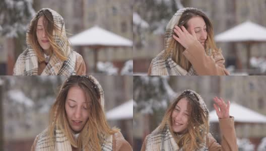 一名妇女抖掉头上的雪，戴上头巾，这样她就可以把落在脸上和头发上的雪清除掉高清在线视频素材下载