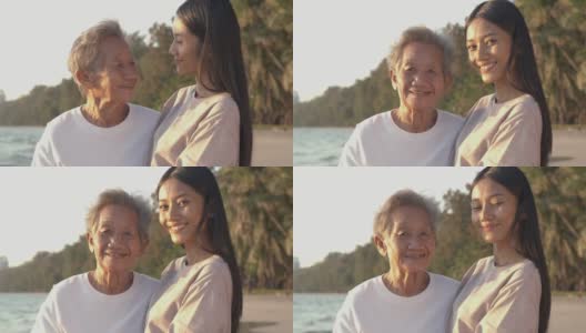 一位老妇人和她的女儿在海边的肖像。他们微笑着看着镜头。高清在线视频素材下载