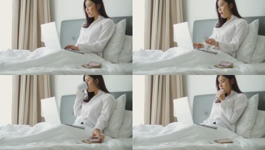 年轻女子一边吃早餐一边在卧室里看笔记本电脑高清在线视频素材下载