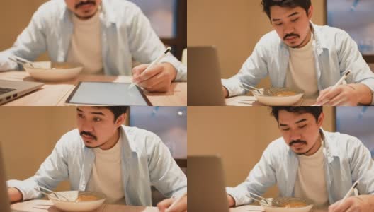 慢动作场景插图画家中东人手使用手写笔在数字平板电脑上创建艺术作品与拉面碗在办公室的截止日期和不健康的工作概念高清在线视频素材下载