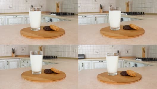 近距离的一杯牛奶与健康的家庭制作的多种谷类饼干。以白色厨房为背景的旋转相机。Dolly-shot。高清在线视频素材下载