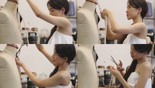 亚洲女性时装或设计师与裁减人体模特工作的一卷织物高清在线视频素材下载