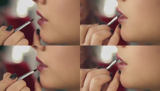 一个专业的化妆师的手使用特殊的刷子应用口红的模特的嘴唇在美容时尚行业工作的特写视图。Slowmotion拍摄高清在线视频素材下载