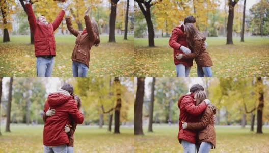 快乐的年轻夫妇在公园里扔秋叶高清在线视频素材下载