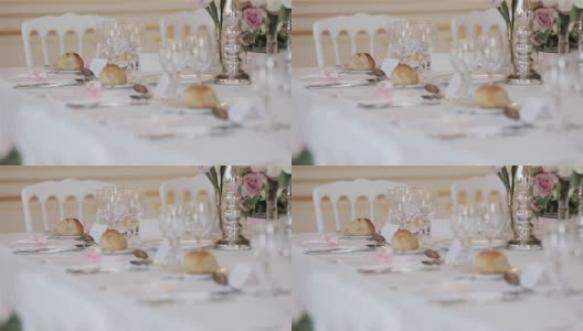 餐具装饰布置的节日餐桌近距离变化，货架焦点细节。婚礼接待桌上的客人位卡，玻璃，餐具，鲜花和面包面包在盘子准备好高清在线视频素材下载