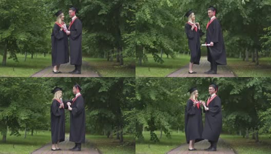 毕业典礼后，男女毕业生在公园里谈笑风生高清在线视频素材下载