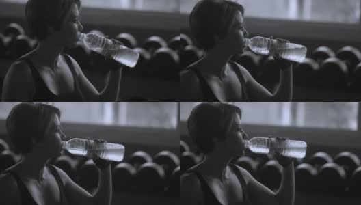 黑与白:女运动员运动后喝水高清在线视频素材下载