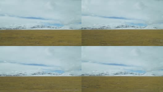 令人惊叹的景象，白云聚集在空旷的平原和雪山高清在线视频素材下载