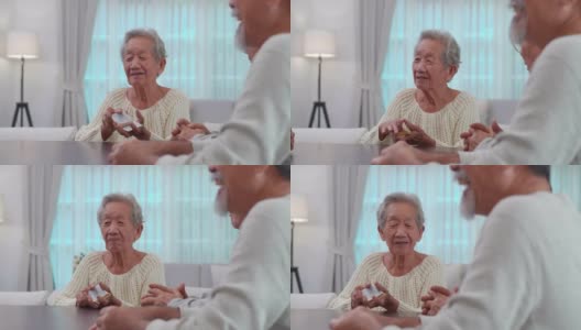一群60-70岁的亚洲活跃老人与一群快乐的老朋友打牌聊天一起在养老院度过美好的时光。社会的老年人高清在线视频素材下载