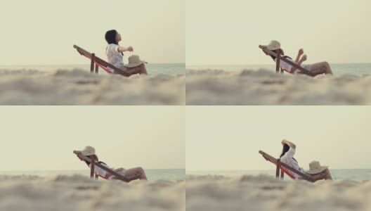 一个亚洲女孩躺在沙滩的躺椅上。高清在线视频素材下载