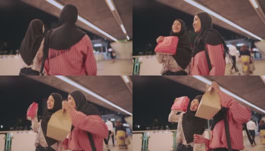 两个年轻的亚洲穆斯林朋友高兴地向镜头展示购物袋，现代穆斯林生活方式，资本主义消费消费，折扣销售产品，享受购物中心，城市生活高清在线视频素材下载