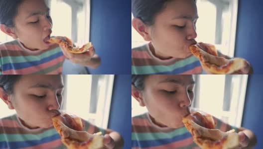 年轻漂亮的女人在家吃披萨。高清在线视频素材下载