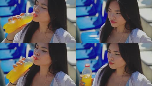 在大热天喝桔子汽水的年轻亚洲女人高清在线视频素材下载