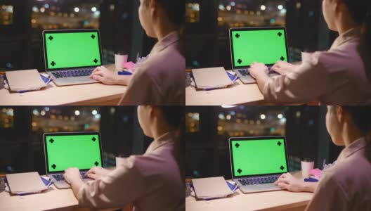 女人在晚上使用绿色屏幕的笔记本电脑高清在线视频素材下载