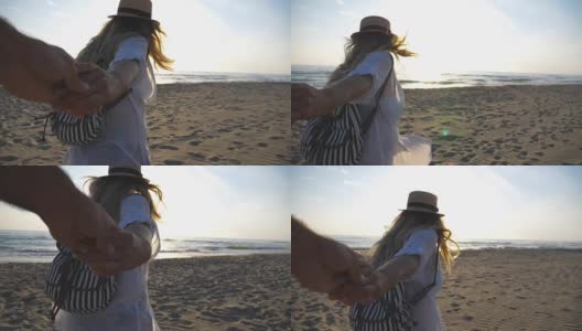 小女孩穿着衬衫，背着双肩包牵着男人的手，带着她去了海边。跟着我拍的幸福美丽的女人戴着帽子拉着男友去海边。情侣在一起度假。夏天旅游的概念。慢高清在线视频素材下载
