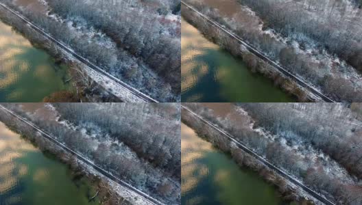 雪地里的铁路天线，紧挨着湖和树高清在线视频素材下载