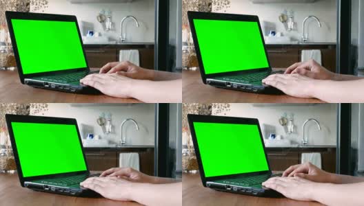 在笔记本电脑上手工操作，绿色屏幕为色度键的客厅-家庭室内场景高清在线视频素材下载