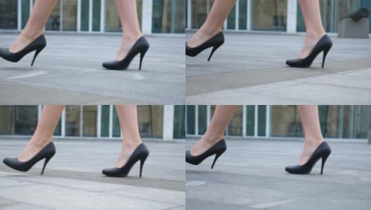 年轻女商人的脚穿着高跟鞋走在城市的街道上。苗条女性的腿在黑色高跟鞋上走在城市。女孩走着去上班。低角度视角慢动作特写高清在线视频素材下载
