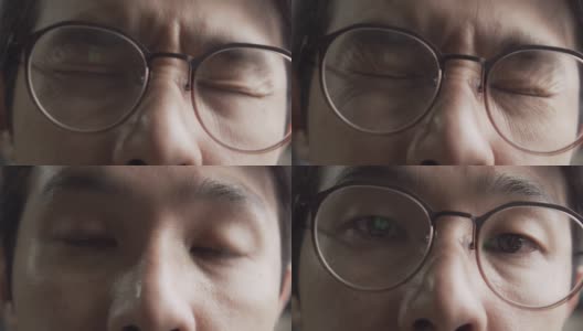 亚洲男人戴着眼镜有压力或抑郁和疲劳的眼睛从电脑工作。使用电脑工作到很晚高清在线视频素材下载