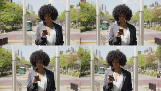 美丽的黑色商务女性在智能手机上发短信，同时享受一个外卖咖啡看起来深思熟虑高清在线视频素材下载