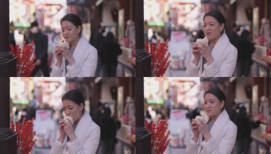 下班后在唐人街吃蒸猪肉包的年轻女子高清在线视频素材下载