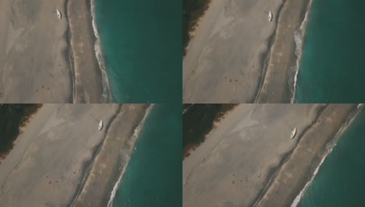 2021年3月春假和2019冠状病毒病期间，佛罗里达州朱诺海滩海滩海岸线上的一艘废弃帆船的动态鸟瞰图高清在线视频素材下载