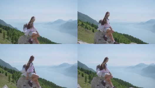 一个小女孩坐在加尔达湖前的山上高清在线视频素材下载