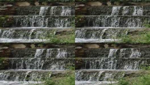 美丽的公园里有小瀑布，水流湍急。高清在线视频素材下载
