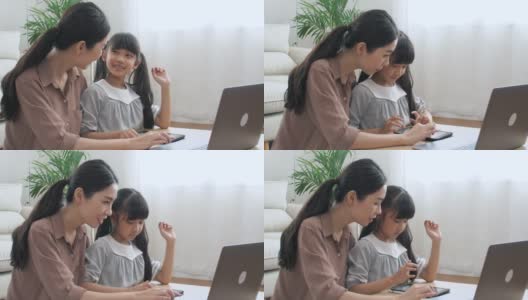 亚洲母亲和女儿与妈妈一起用笔记本电脑做作业高清在线视频素材下载