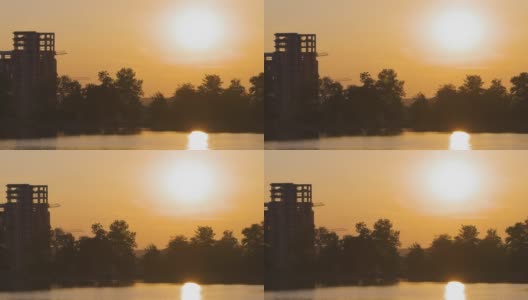 湖滨景观，在明亮的夕阳下，建筑物倒影在湖水中，远处的行人在堤岸上行走高清在线视频素材下载