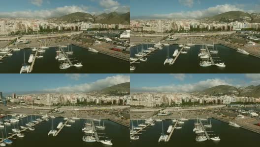 航拍:一个有帆船和游艇的码头的摇摄。在港口附近可以看到城市建筑高清在线视频素材下载