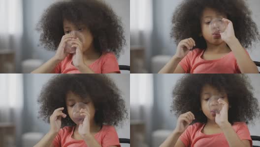 口渴的美国黑人孩子喝着矿泉水，这是孩子脸的特写高清在线视频素材下载