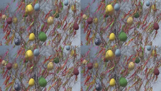 布拉格的一棵五颜六色的复活节树在刮风的日子里用一些巨大的复活节彩蛋和一些五颜六色的丝带装饰着。高清在线视频素材下载