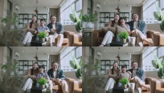 幸福甜蜜的亚洲家庭爸爸妈妈和儿子坐在沙发上看电影从电视在家里。笑笑亚洲家庭居家隔离隔离时刻在封锁国家秩序。高清在线视频素材下载