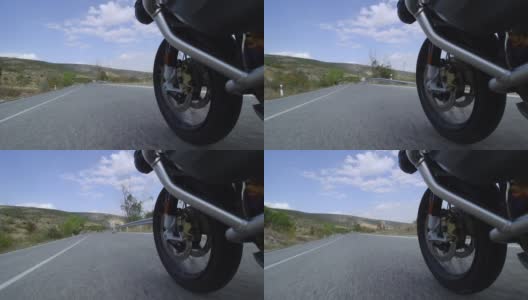 在自然的道路上骑摩托车。从路中间的一头牛旁边经过。记录在100帧每秒。高清在线视频素材下载
