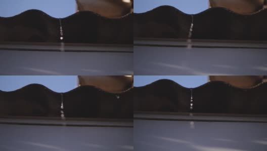 一股融水从屋顶的石板上滴落下来。水滴从屋顶上流下来。慢镜头180帧/秒高清在线视频素材下载