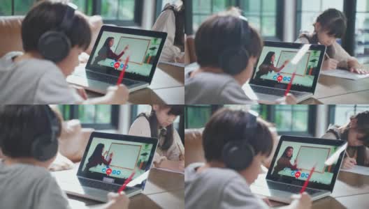 由于冠状病毒大流行，亚洲小男孩通过数字远程互联网会议从学校老师那里学习在线课程。孩子看着电脑笔记本电脑屏幕，那个女人在教书。高清在线视频素材下载