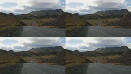 在多云的天气里，白色的汽车在风景如画的冰岛山脉之间的公路上行驶高清在线视频素材下载