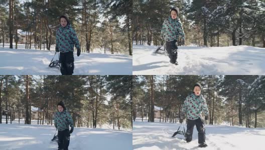 在阳光明媚的冬日里，小男孩拉着雪橇上山。高清在线视频素材下载