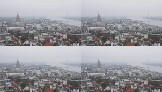里加,拉脱维亚。顶视图城市景观在薄雾雨天。拉脱维亚科学院，建立在莫斯科斯大林摩天大楼模型，公共汽车站，国际长途汽车站和中央市场高清在线视频素材下载