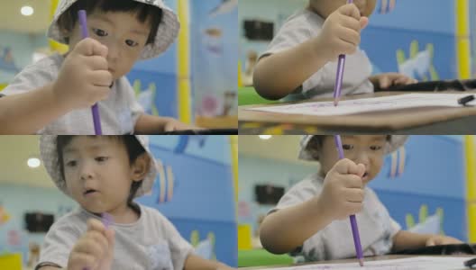 小男孩正在桌子上画画。高清在线视频素材下载