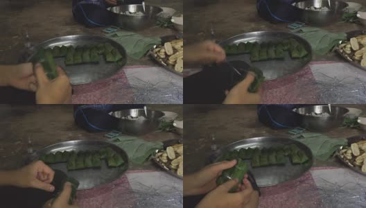 一个女人用糯米在芭蕉叶里蒸，用手做香蕉高清在线视频素材下载