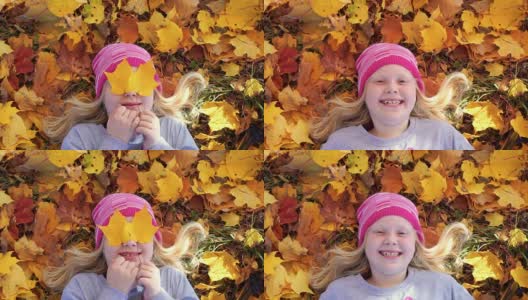 一个美丽的女孩的肖像在秋天公园的落叶上高清在线视频素材下载