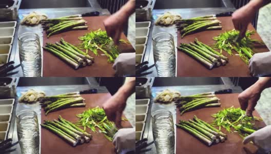 在厨房的背景上，手正在用一把特制的刀削绿芦笋高清在线视频素材下载