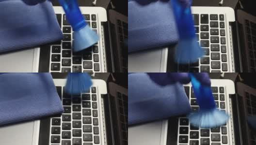 一个戴着橡胶手套的男人正在清洁他的笔记本电脑。一种特殊的刷子可以清除键盘和笔记本电脑屏幕上的灰尘。保护工作设备免受病毒感染。高清在线视频素材下载