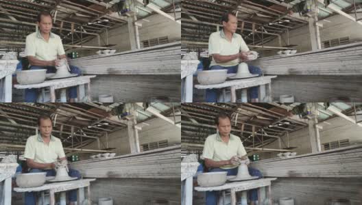 慢镜头，亚洲华人活跃的高级陶工在他的工作室用旋转的陶轮工作高清在线视频素材下载