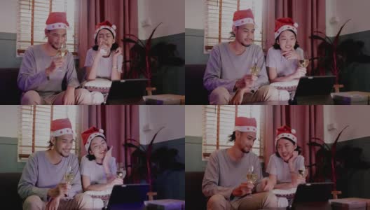 家庭年轻的亚洲夫妇坐在一起庆祝。在圣诞节与朋友视频通话，并在家里祝新年快乐。喝香槟，在平板电脑上在线看电影。通信技术高清在线视频素材下载