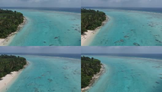 热带海滩的风景。美丽的海浪，绿色的棕榈树，蓝色的水和天空的马尔代夫高清在线视频素材下载